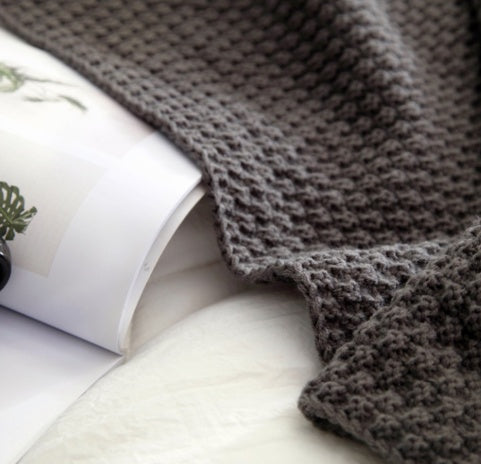 Nordisk bollstickad filt med tofsar – varm, mjuk och stilren